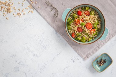 A healthy snack, lunch or dinner. Bowl of pearl barley with broad beans and cherry tomatoes. A healthy snack, lunch or dinner. Vegan comfort food. View from the top. Place for tekst. clipart