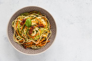 Jülyen sebzeli spagetti, havuç, kabak ve güneşte kurutulmuş domates. Sağlıklı vejetaryen yemeği. Üst görünüm, alanı kopyala.