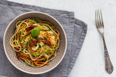 Jülyen sebzeli spagetti, havuç, kabak ve güneşte kurutulmuş domates. Sağlıklı vejetaryen yemeği. Üst görünüm, alanı kopyala.