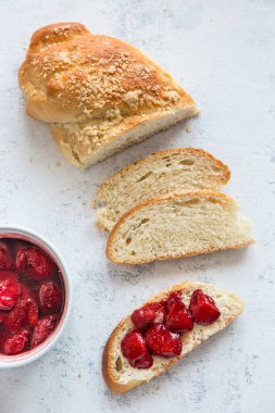 Ev yapımı challah az önce yahudi mutfağında özel bir ekmek pişirdi. Sandviç, vejetaryen tereyağı ve haşlanmış çilek. Vegan seçeneği.