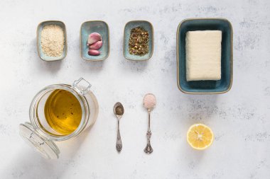 Terbiye edilmiş tofu, pasif maya taneleri, sarımsak, otlar, zeytin, limon suyu, tuz ve biber..