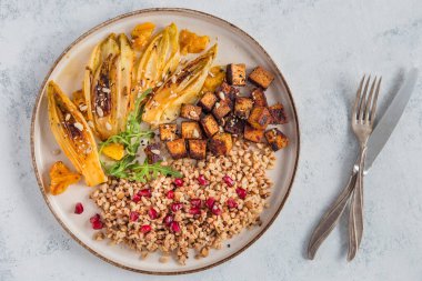 Lezzetli ve sağlıklı vegan yemeği ya da öğle yemeğinde düşük kalorili ve yüksek proteinli. Karabuğday, hububat ve nar, hindiba, portakal ve kızarmış tofu ile yetişir..