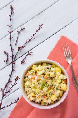 Kaynamış kök sebzeli salata, salatalık turşusu, elma, mayonez ve hafif ahşap arka planda bir kasede. Parlak bir arka planda geleneksel Polonya salatası. Üst görünüm, düz görünüm.