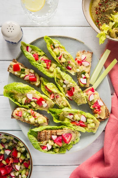 Çiğ vejetaryen taco yemeği. Humus ve domatesli marul, lahana, salatalık, turp ve kereviz salatası..
