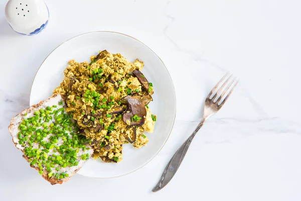 Scramble tofu with mushrooms,  vegan alternative. White background.