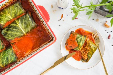 Pirinç ve vejetaryen etiyle doldurulmuş lahana yaprakları, domates sosuyla fırında pişirilmiş, Golabki adında bir tabak Polonya mutfağı. Üst görünüm, yakın çekim, düz çizgi.