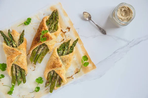 Parmesanlı vejetaryen peynirli puf böreğinde pişirilmiş yeşil kuşkonmaz. Tekst için yer.
