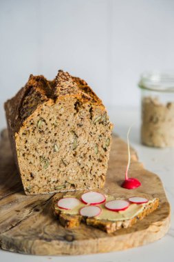 Dikdörtgen bir somun ekmek, arka planda geleneksel ekşi ekmek. Geleneksel mayalanmış ekmek pişirme yöntemleri kavramı. Sağlıklı yemek..