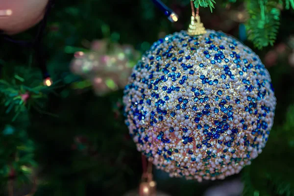 Weihnachtskugel mit blauen Glassteinen auf einem festlichen Baum. Dunkler verschwommener Hintergrund. Geringe Schärfentiefe. Makro. — Stockfoto