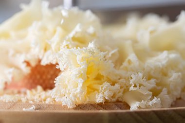 Ahşap bir yüzeyde peynir dokusu olan bulanık bir arkaplan. Yüzeyin derinliği. Peynirin Makro resmi.