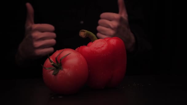 Mannen hand visar ett finger upp bakom grönsaker tomat och färgad peppar — Stockvideo