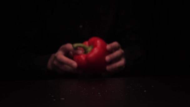 Mens ręce umieścić na stole czerwony kolor papryki dzwonek na ciemnym tle — Wideo stockowe