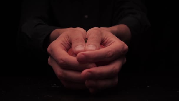 Мужские руки предлагают держать две части помидора на темном фоне — стоковое видео