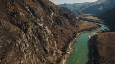 Sakin dağ yeşil Katun Nehri 'nin havadan görünüşü. Altai Bölgesi 'nin vahşi sonbahar manzarası: ağaçlarla, altın ormanlarla, tarlalarla, güneş ışınlarıyla dolu büyük bir dağ. Altai.