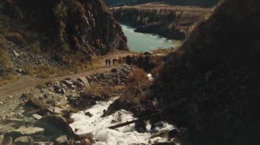 Sakin dağ nehri Katun 'un havadan görünüşü. Altai Bölgesi 'nin vahşi sonbahar manzarası: dağlar, ormanlar, tarlalar, bir ülke yürüyüş yolu, bir dağ deresi, güneş ışınları.