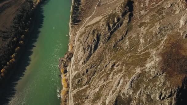 Aerial view of the calm mountain green Katun River. Autumn landscape of the wild nature of the Altai Territory: a huge mountain with trees, a golden forest, a field, the rays of the sun. Altai — Stock Video