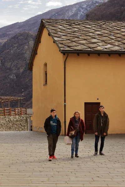 İtalyan Alpleri 'ndeki bir köye yaptığı ziyarette iki çocuklu bir anne, taştan bir yolda yürüyor. — Stok fotoğraf