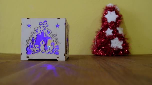 Close-up beelden van een gesneden houten doos met kerstboomverlichting — Stockvideo