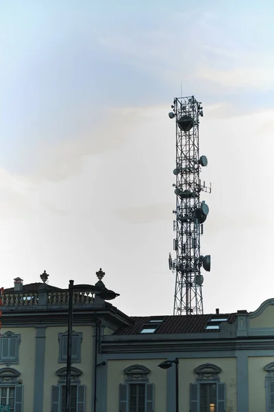 Urban electromagnetic pollution: a huge telephone antenna mounted between the roofs of houses — Stock Photo, Image