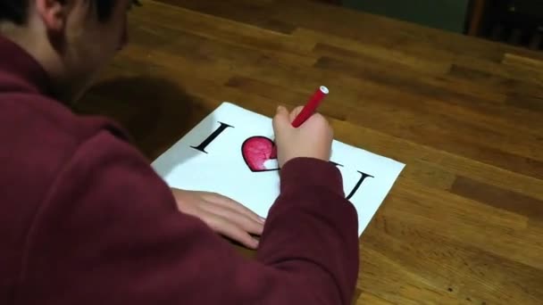 Garçon caucasien dédie un dessin avec les mots I Love U à la fille bien-aimée — Video