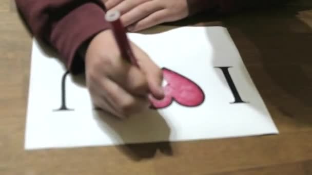 코카서스 소년은 내가 사랑하는 소녀에게 바치는 단어와 함께 그림을 완성 한다 — 비디오
