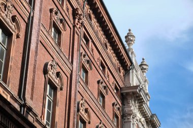 Kırmızı tuğlalı bir sarayın Art Nouveau cephesinde mermer başkentler