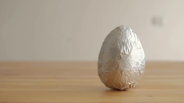 Caucasian boy sees a chocolate easter egg on the table and takes it — Stock video