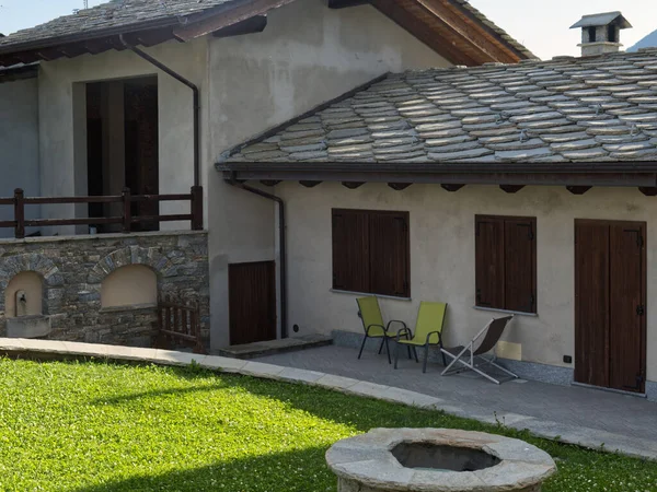 Fachada e jardim de uma bela residência alpina com os tetos de pedra típicos — Fotografia de Stock
