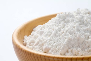 Beyaz arka planda izole edilmiş tahtadan bir kasede buğday unu. yakın plan.