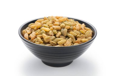 Beyaz arka planda izole edilmiş siyah bir kasede kuru üzümler.