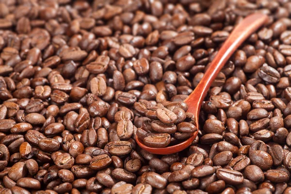 Colher de madeira com grãos de café — Fotografia de Stock