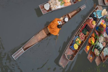 Ratchaburi, Tayland - 18 Eylül 2020: Damnoen Saduak Yüzen Pazarı 'ndaki keşişe sadaka veren ahşap tekne tüccarı, tekneyle gezen turistler Tayland kanallarında popüler bir turizm merkezidir..