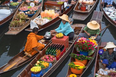 Ratchaburi, Tayland - 18 Eylül 2020: Damnoen Saduak Yüzen Pazarı 'ndaki keşişe sadaka veren ahşap tekne tüccarı, tekneyle gezen turistler Tayland kanallarında popüler bir turizm merkezidir..