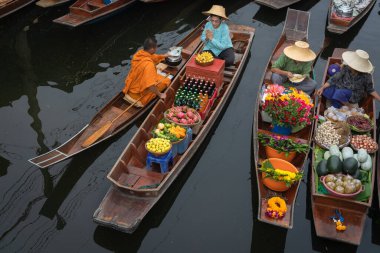 Ratchaburi, Tayland - 18 Eylül 2020: Damnoen Saduak Yüzen Pazarı 'ndaki keşişe sadaka veren ahşap tekne tüccarı, tekneyle gezen turistler Tayland kanallarında popüler bir turizm merkezidir..