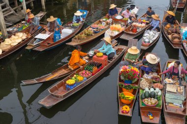 Ratchaburi, Tayland - 18 Eylül 2020: Damnoen Saduak Yüzen Pazarı 'ndaki keşişe sadaka veren ahşap tekne tüccarı, tekneyle gezen turistler Tayland kanallarında popüler bir turizm merkezidir..