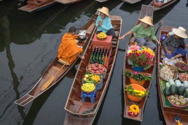 Ratchaburi, Tayland - 18 Eylül 2020: Damnoen Saduak Yüzen Pazarı 'ndaki keşişe sadaka veren ahşap tekne tüccarı, tekneyle gezen turistler Tayland kanallarında popüler bir turizm merkezidir..