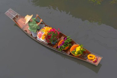 Ratchaburi, Tayland - 18 Eylül 2020: İnsanlar Damnoen Saduak Yüzen Pazarında ahşap teknede Tayland mutfağı satıyorlar. Tekneyle gezen turistler Tayland kanallarında popüler turistik ilgi odağıdır..