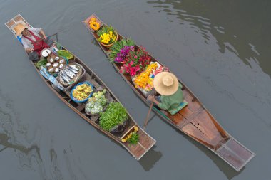 Ratchaburi, Tayland - 18 Eylül 2020: İnsanlar Damnoen Saduak Yüzen Pazarında ahşap teknede Tayland mutfağı satıyorlar. Tekneyle gezen turistler Tayland kanallarında popüler turistik ilgi odağıdır..