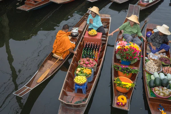 Ratchaburi, Tayland - 18 Eylül 2020: Damnoen Saduak Yüzen Pazarı 'ndaki keşişe sadaka veren ahşap tekne tüccarı, tekneyle gezen turistler Tayland kanallarında popüler bir turizm merkezidir..