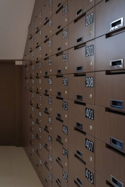 Bir apartmanda ya da apartmanda posta kutuları. Sıra sıra ahşap posta kutuları ve girişteki kilitler. Posta kutusu konseptini kontrol etmek için apartman dairesi.
