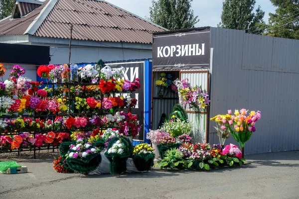 Mezarlığın yakınındaki mezarları dekore etmek için yapay çiçekler. Rus geleneği. Rusya, Krasnoyarsk, Badalyk Mezarlığı, 21 Ekim 2020.