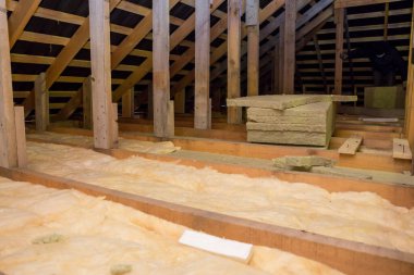 Tavanda fiberglasla yalıtım. Soğuğa karşı bir bariyer için taş yünü ve fiberglas yalıtım malzemesiyle kaplama ve yalıtım. Konforlu ekonomik konut kavramı.