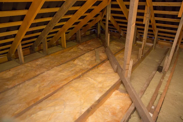 Insulation of the ceiling with fiberglass. Laying and insulation with stone wool and fiberglass insulation material for a barrier against cold. The concept of a comfortable economical home.