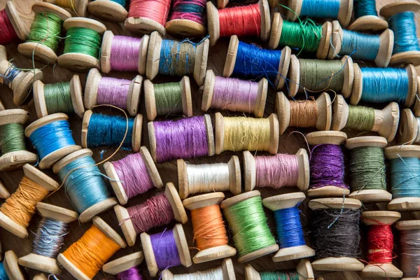 Arka plan, ahşap eski makaralardaki renkli ipliklerden yapılmış. Renkli iplik derileri. Üst görünüm