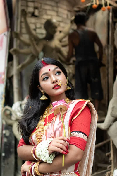 伝統的なインドの風景 金のジュエリー バングルを身に着けているドゥルガアイドルの前に立つ美しいインドの少女の肖像画 Maa Durga Agomoni撮影コンセプト — ストック写真
