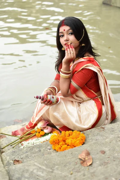 照片中美丽的印度女孩穿着传统的印度萨里 头戴黄金首饰 手持带有宗教祭祀的Gach Kouto的手镯 站在甘加河前 — 图库照片