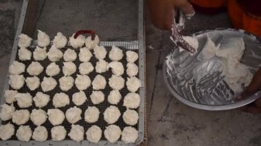 Hintli kadın güneşli bir günde Daler Bori 'yi internette hazırlıyor. Bengali mutfağında popüler olan bir çeşit kurutulmuş mercimek köftesi..