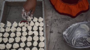 Hintli kadın güneşli bir günde Daler Bori 'yi internette hazırlıyor. Bengali mutfağında popüler olan bir çeşit kurutulmuş mercimek köftesi..