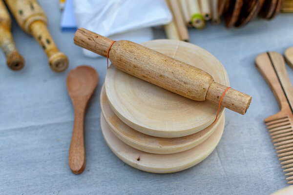 Изображение ручной работы производителя деревянных роти отображается в магазине для продажи на размытом фоне. Индийское ремесло. (Selective Focus)