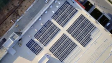 Elektrik üreten fabrikanın çatısındaki güneş panellerinin insansız hava aracı görüntüsü. Yeşil enerji